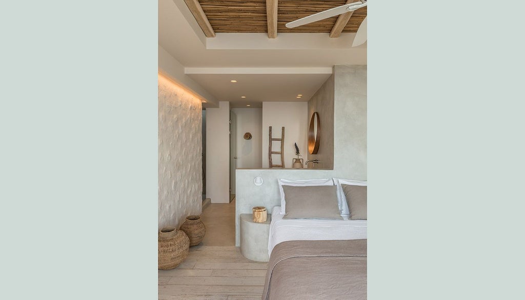 Minimalist white Cycladic suite with panoramic Aegean Sea view, elegant four-poster bed, and sleek modern design highlighting Greek island luxury hospitality