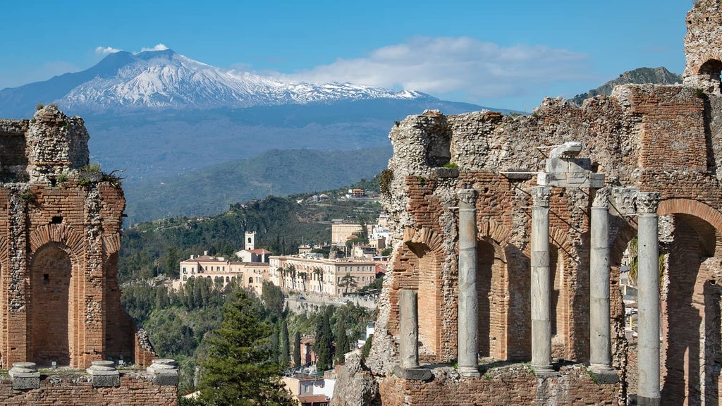 Cliffside luxury hotel overlooking Ionian Sea with infinity pool, elegant stone architecture and manicured gardens in Taormina