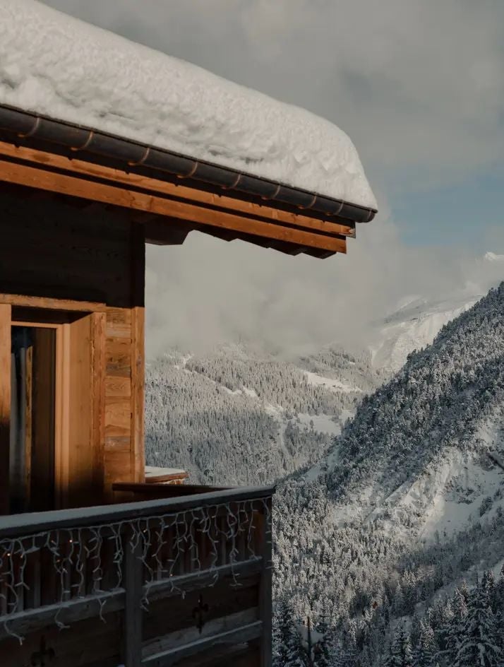 Luxurious alpine ski resort hotel nestled in snow-covered Courchevel mountains, featuring modern chalet-style architecture with expansive windows and elegant design