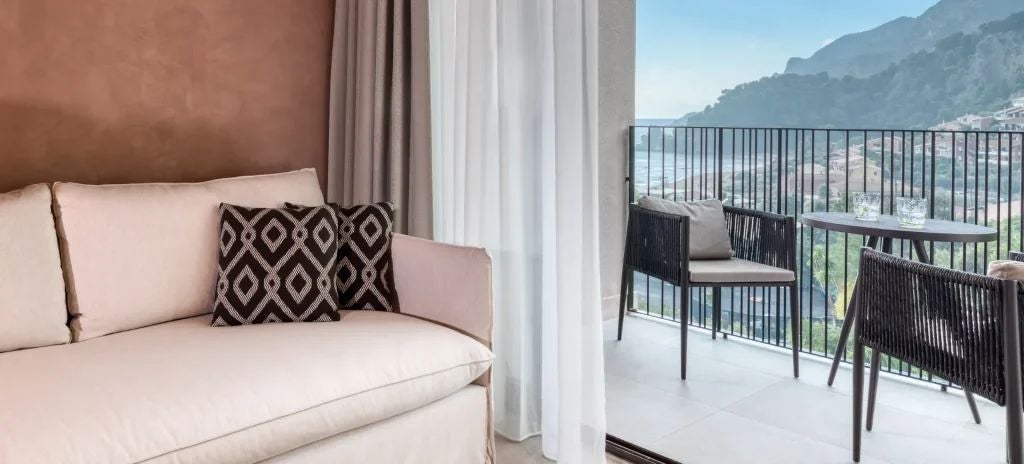 Luxurious Sapphire Junior Suite at Domes of Corfu, featuring elegant white bedding, modern decor, and a private balcony with stunning Ionian Sea view