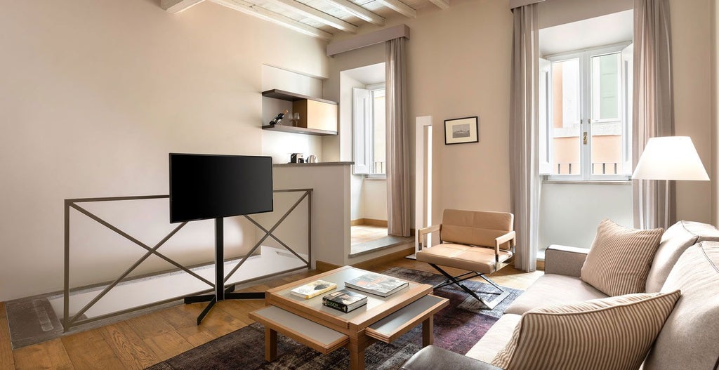 Elegant Italian hotel room with ornate chandelier, antique wooden furniture, and plush cream-colored bedding in historic Palazzo Scanderbeg Annex