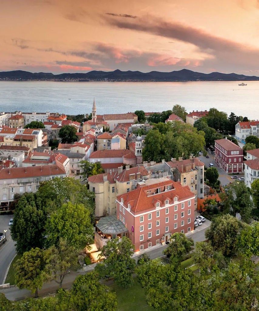 Historic stone-walled Hotel Bastion in Zadar, Croatia featuring elegant balconies, traditional architecture and Mediterranean landscaping