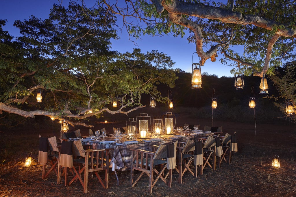 Luxurious safari lodge suite with infinity pool overlooking vast African savanna, backed by dramatic Malilangwe mountains in golden light