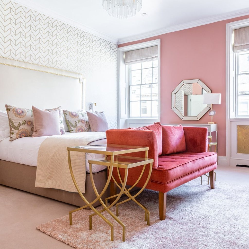 Elegant four-poster bed adorned with luxurious linens, set against refined period decor in a classic British hotel suite with soft, warm lighting.