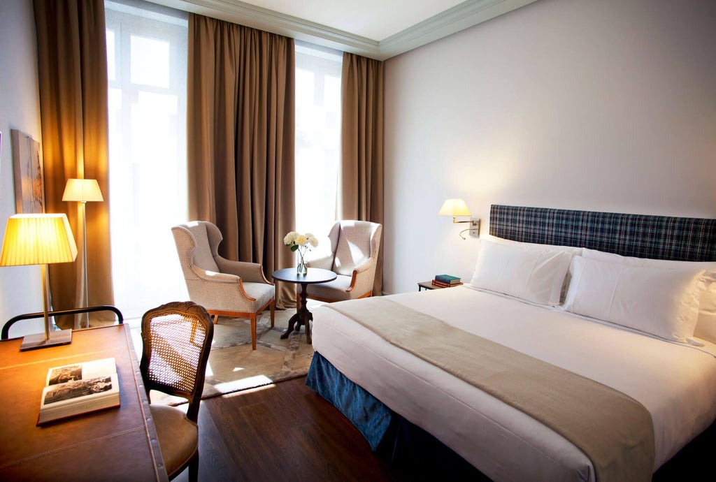 Elegant deluxe hotel room at URSO Hotel & Spa in Madrid, featuring plush king bed, classic Spanish architectural details, and refined city palace view