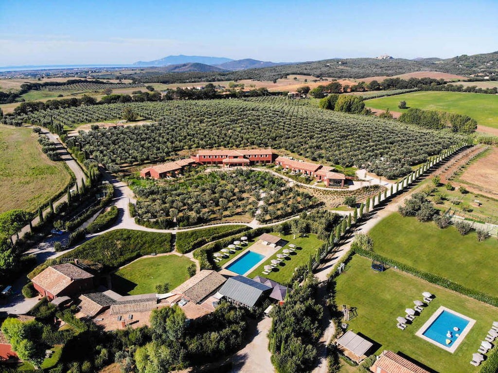 Rustic Tuscan hotel nestled among rolling vineyards, with stone facade, terracotta roof, and lush Mediterranean garden bathed in warm golden sunlight