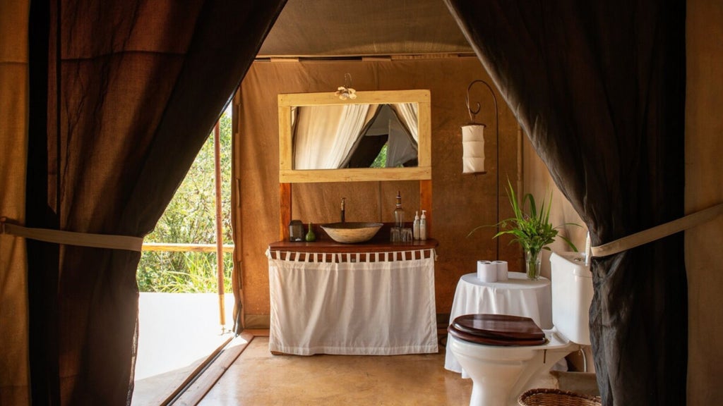 A luxurious raised safari tent with private deck overlooks the Mara wilderness, canvas walls draped elegantly beneath wooden beams