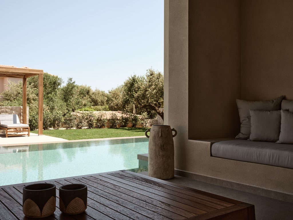 Luxurious white-washed Greek villa bedroom with panoramic sea view, elegant minimalist design, and private terrace overlooking Aegean coastline at sunset