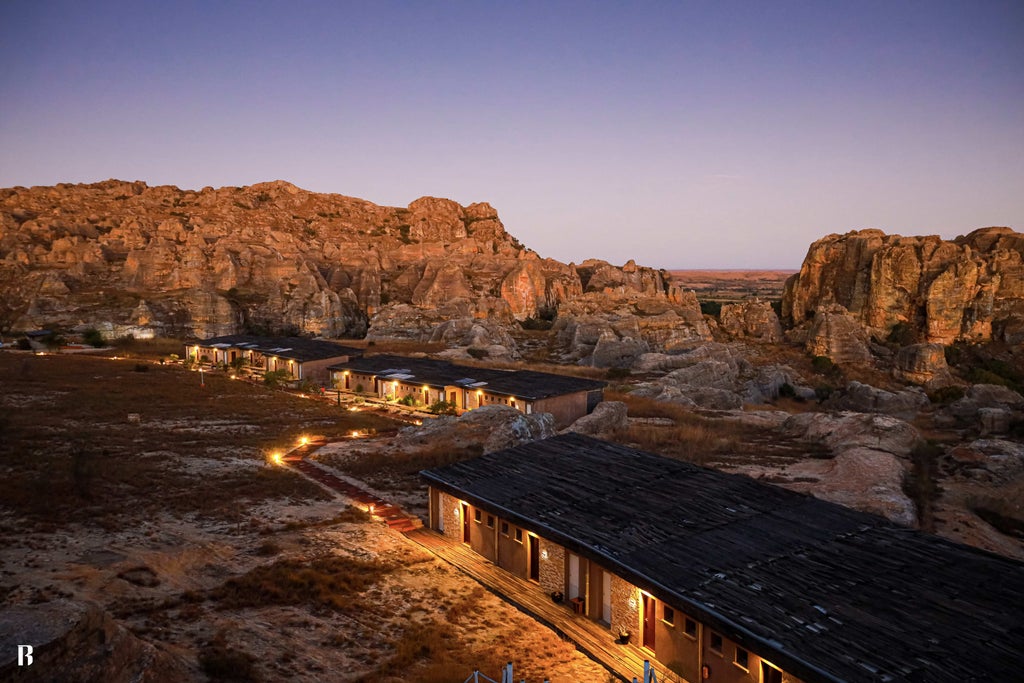 Remote luxury lodge perched on rocky outcrop overlooking Madagascar's Isalo landscape, featuring infinity pool and stone architecture