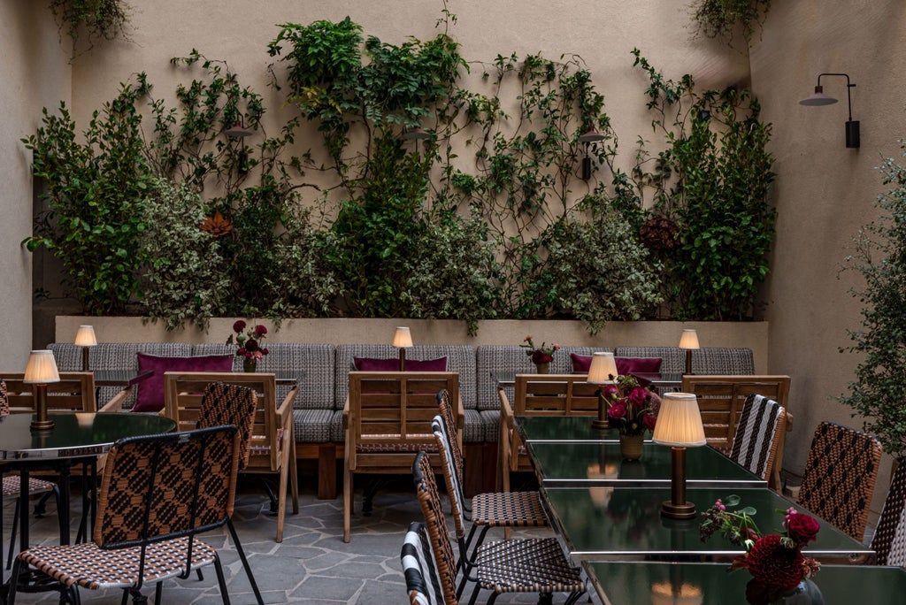 Historic French boutique hotel with ornate stone facade, wrought-iron balconies, and elegant arched windows overlooking a charming cobblestone street