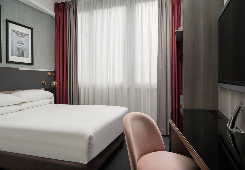 Cozy modern small double room at iQ Hotel in Firenze, featuring sleek design, crisp white linens, minimalist furniture, and warm ambient lighting