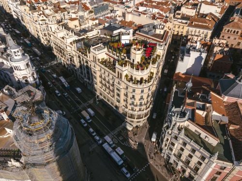 Opulent neoclassical hotel facade in Madrid's city center, featuring grand stone architecture with elegant balconies and ornate architectural details