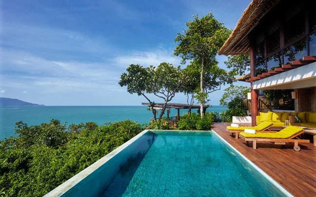 Private infinity pool overlooking turquoise ocean and lush tropical forest at Six Senses luxury resort in Koh Samui, Thailand