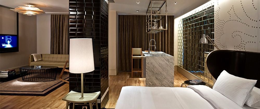 Luxurious king bedroom at scenset Istanbul hotel with modern minimalist design, sleek dark wood furnishings, and city-view windows with soft neutral tones