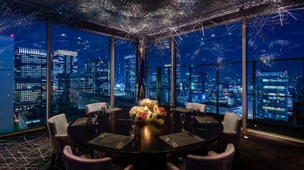 Elegant Peninsula Hotel Bangkok with traditional Thai-style architecture reflecting in river at sunset, illuminated facade glowing gold