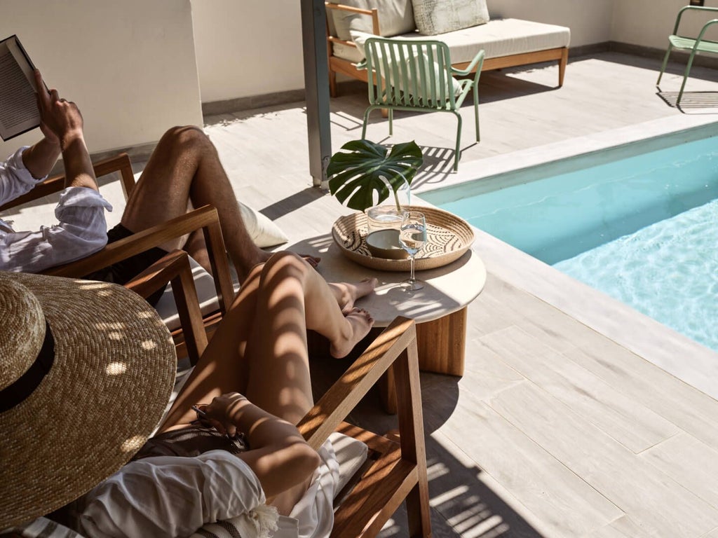 Luxurious king suite with private pool overlooking azure Cretan coastline, featuring modern design and elegant evergreen-inspired furnishings at beachfront resort