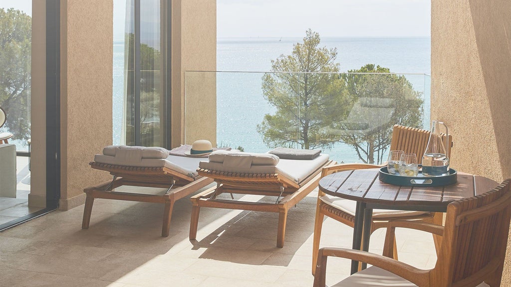 Luxurious junior suite with private hot tub overlooking Aegean Sea, featuring modern minimalist design and warm wooden accents in scenic scenset, Greece