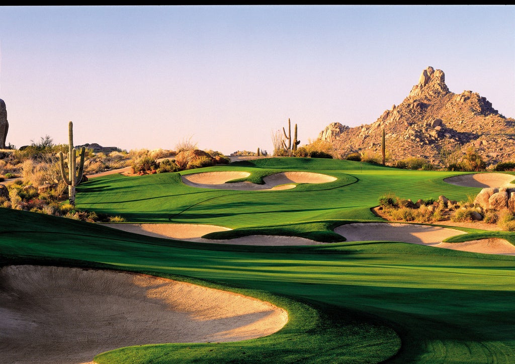 Luxurious desert resort surrounded by saguaro cacti, with adobe-style architecture blending into red rock formations of Arizona landscape