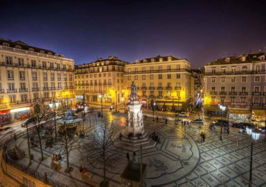 Elegant 18th-century boutique hotel in Lisbon's historic district with ornate yellow facade, wrought-iron balconies and traditional architecture