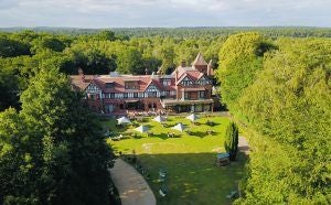 Historic luxury hotel exterior with elegant stone facade, traditional sash windows, and manicured garden in Malton, United Kingdom, showcasing refined British architectural charm.