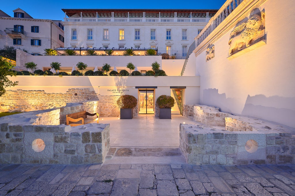 Elegant 5-star hotel Palace Elizabeth overlooking Hvar's harbor, featuring ornate Venetian-style architecture and grand balconies at sunset