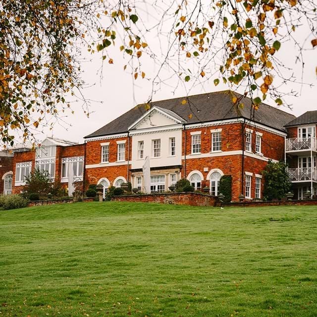 Luxury country house hotel with manicured gardens, elegant exterior, and traditional English architecture nestled in lush Hampshire landscape