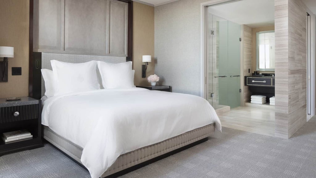 Elegant superior room at luxury hotel with contemporary design, king bed, plush bedding, city views, and sophisticated neutral color palette in Boston