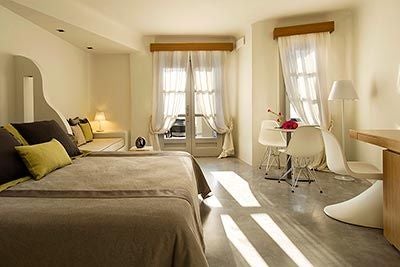 Elegant superior room at Avaton Resort & Spa with minimalist design, white decor, private balcony overlooking azure Aegean Sea, luxurious bedding and modern amenities