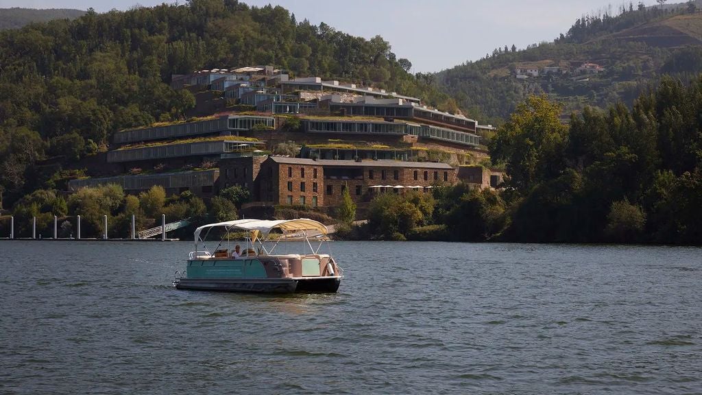 Luxury hillside hotel overlooking Douro Valley vineyards, featuring an infinity pool with panoramic views of the terraced landscape