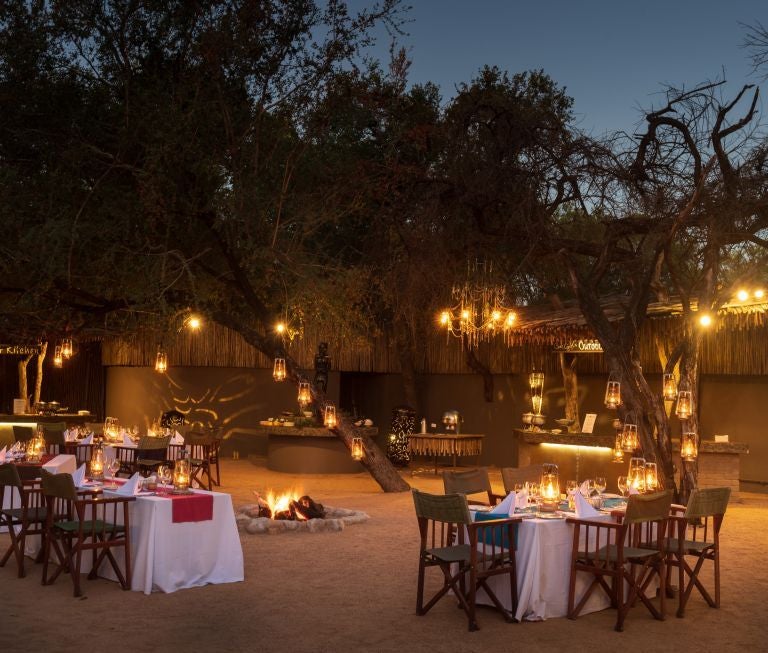 Luxurious safari lodge suite with private plunge pool overlooking African bushveld, featuring thatched roof and wooden deck terrace