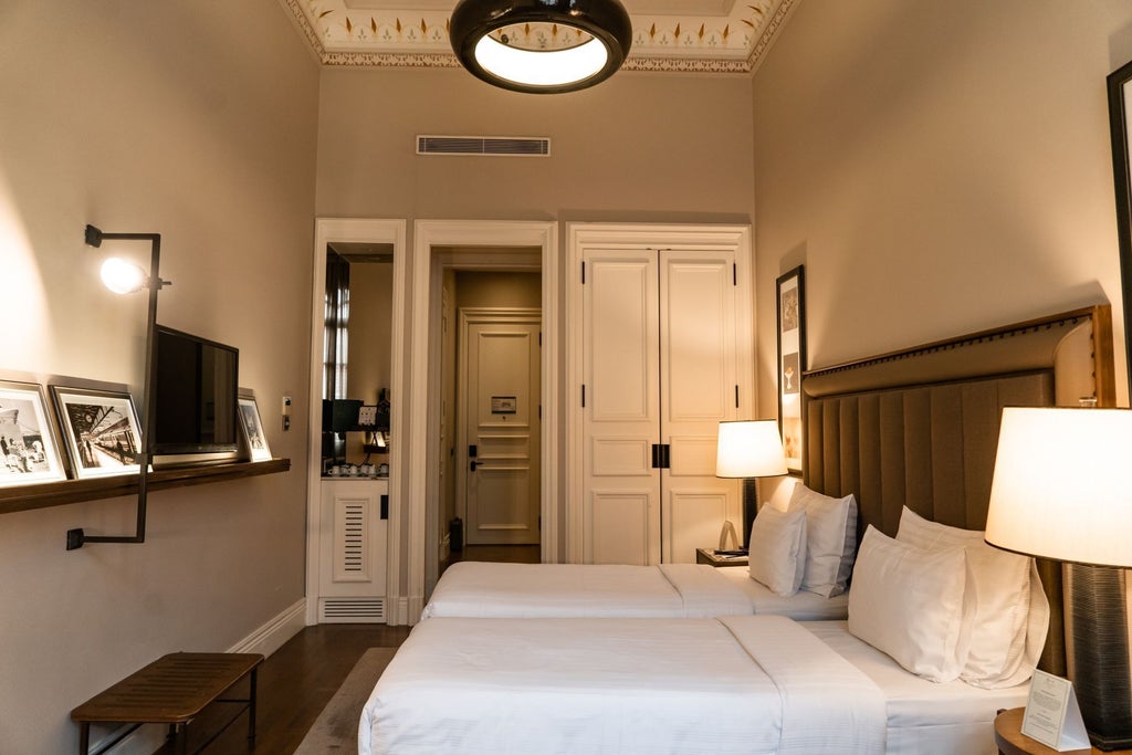 Elegant deluxe twin room with contemporary design, plush white bedding, large windows, and sophisticated decor at scenset hotel in Istanbul, Turkey.