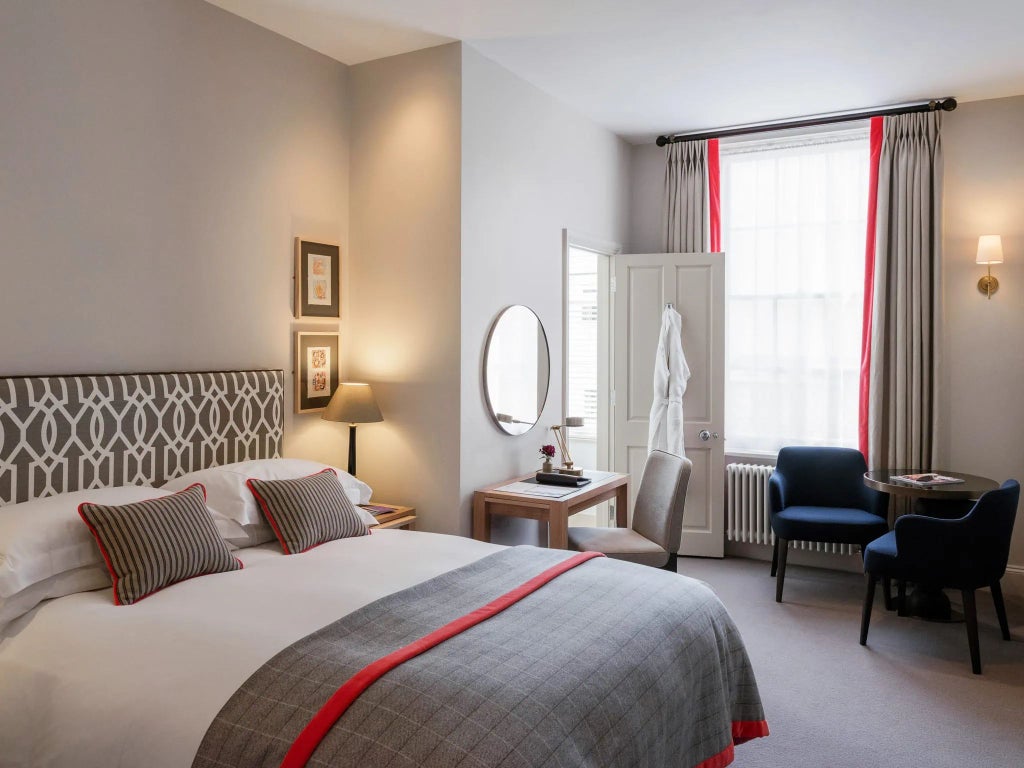 Elegant classic hotel room with crisp white linens, traditional wooden furnishings, soft neutral tones, and large windows at Old Parsonage Hotel in United Kingdom