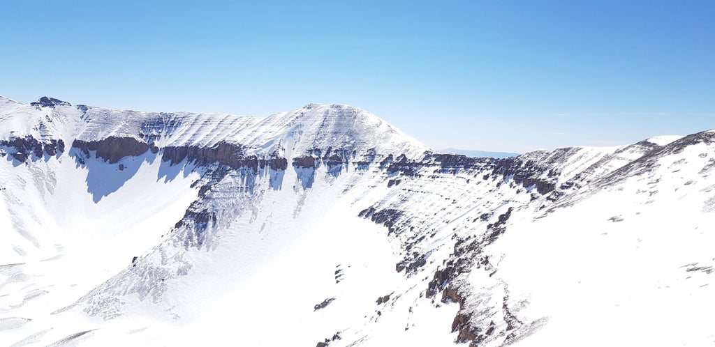 Scenic hiking trail winding through rugged Atlas Mountains, revealing breathtaking Moroccan landscape with distant peaks, rocky terrain, and golden sunlight