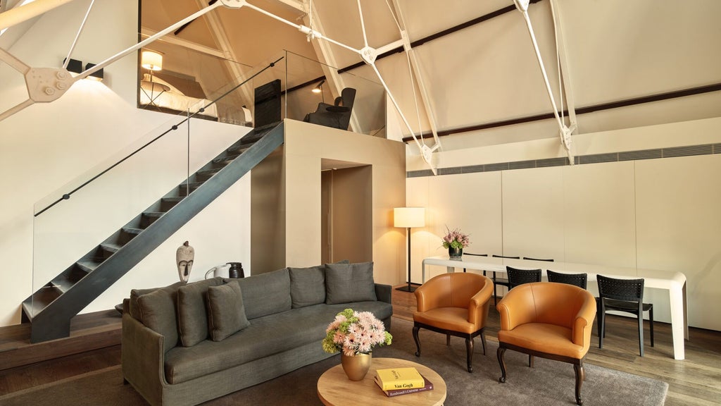 Luxurious two-bedroom suite at Conservatorium Hotel, Amsterdam, featuring modern design, elegant furnishings, and expansive city views through large windows.