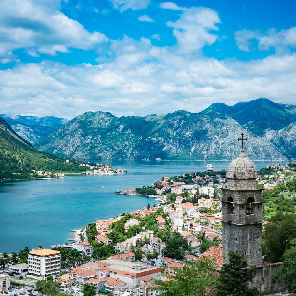 Stunning panoramic view of Boka Bay in Montenegro, with medieval red-roofed buildings nestled between mountains and azure waters