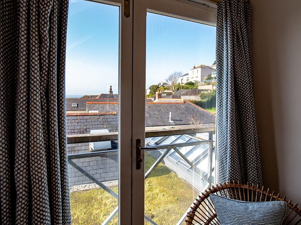 Charming coastal village room at scenset Hotel with nautical-inspired decor, crisp white linens, and panoramic views of Cornwall's picturesque seaside landscape