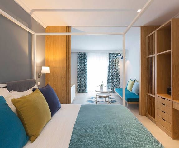 Luxurious panoramic sea-view suite at Eagles Palace hotel, featuring elegant furnishings, expansive balcony, and sweeping Aegean coastline in Greece