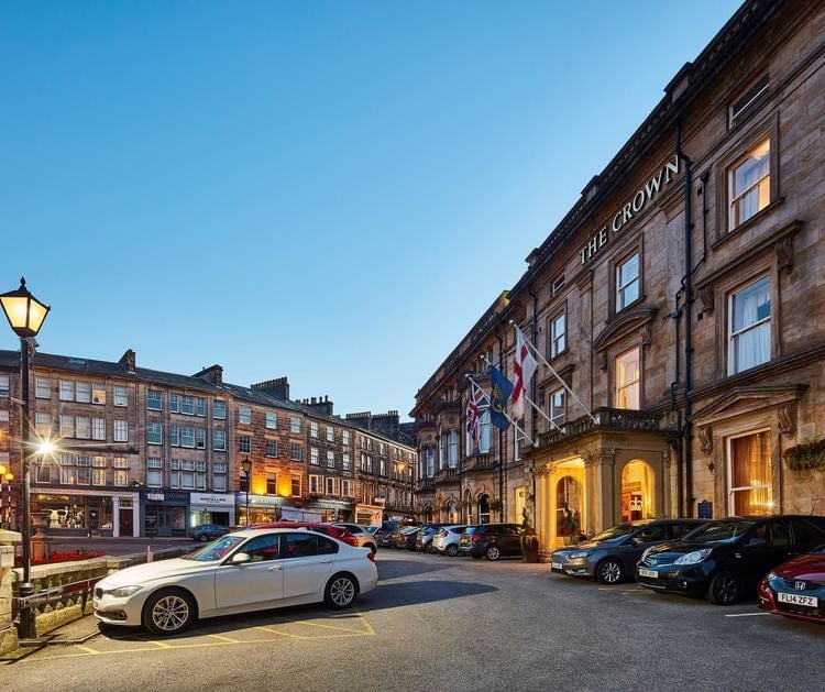 Elegant exterior of a luxurious British hotel with classic architectural details, stone facade, and manicured gardens in the United Kingdom