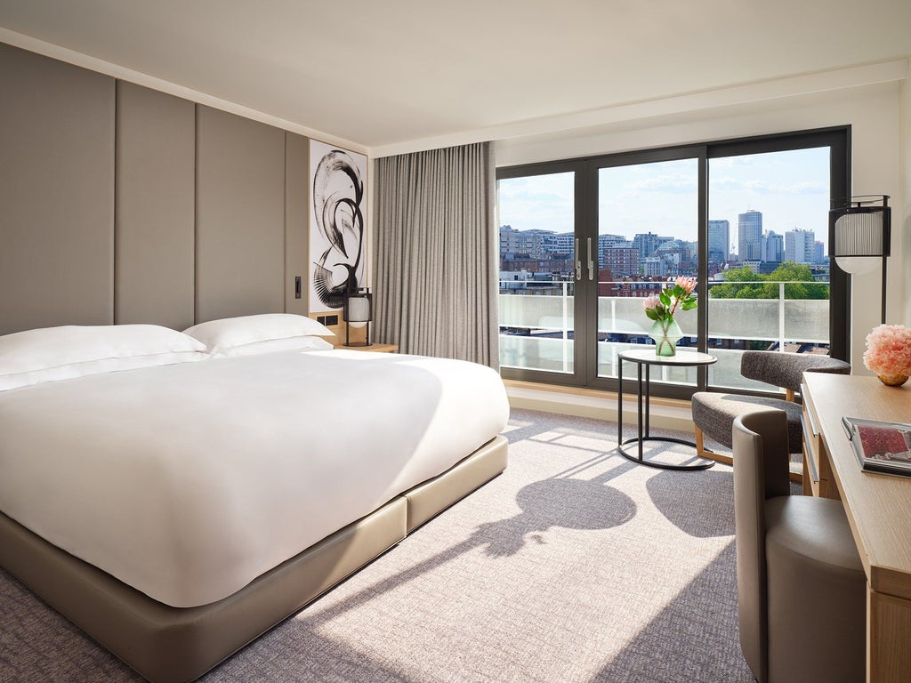 Elegant superior room at Nobu Hotel featuring plush king bed, minimalist design, warm wood tones, and contemporary luxury furnishings with city view