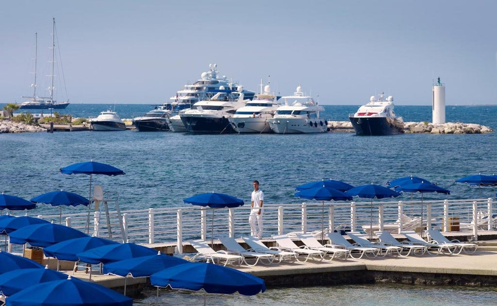 Mediterranean art deco hotel Belles Rives with elegant white facade and blue shutters overlooking French Riviera's crystal waters