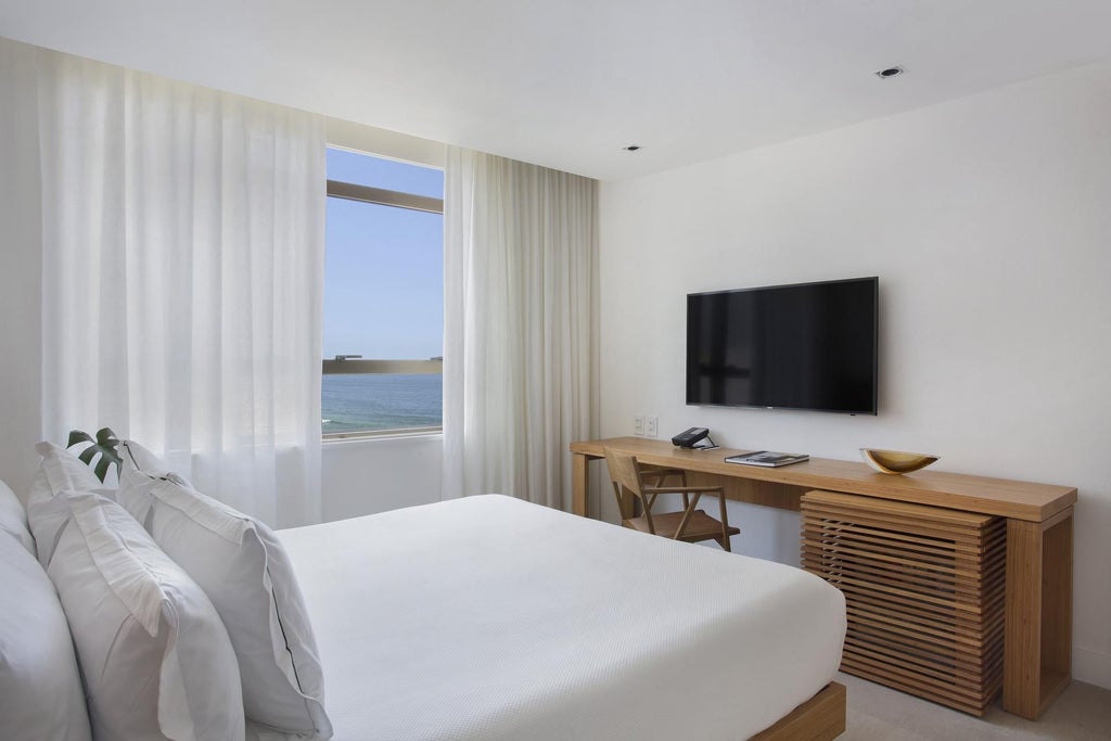 Luxurious Janeiro Hotel room with elegant Brazilian-inspired design, crisp white linens, modern minimalist furniture, and panoramic ocean view.