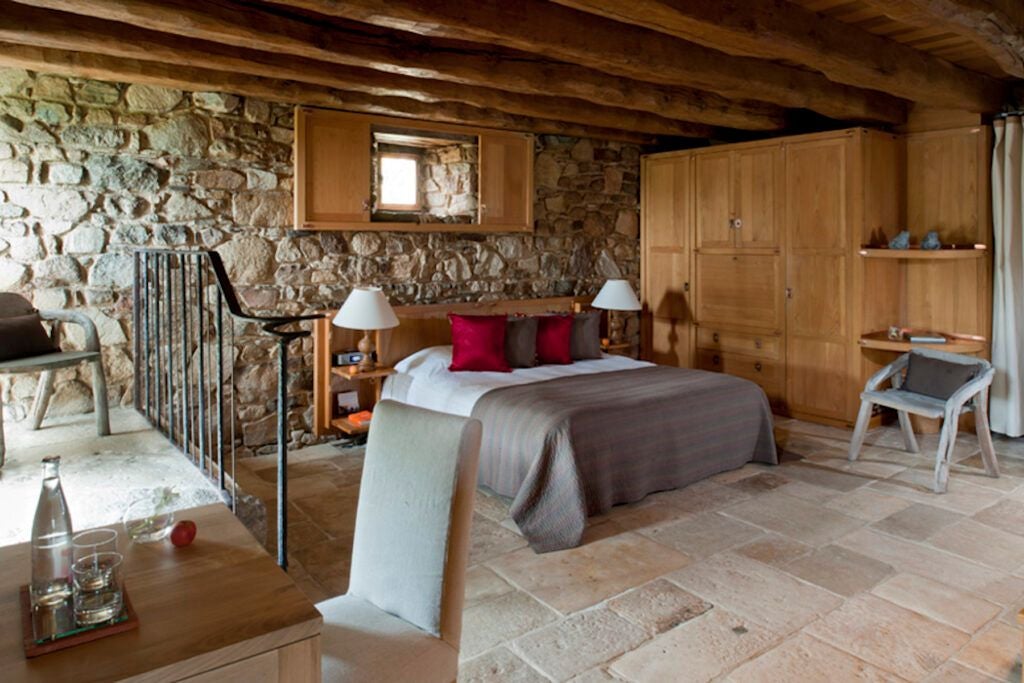 Luxurious rustic cottage room with dragon-themed decor, soft natural light, plush textiles, and elegant wooden furnishings at scenic countryside estate in France