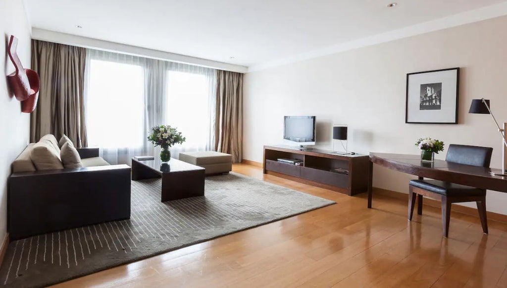 Elegant Park Deluxe Suite with king bed, crystal chandelier, marble bathroom, and French windows overlooking Buenos Aires gardens