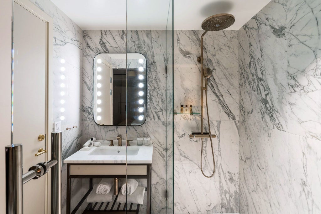 Luxurious minimalist hotel room with bank vault aesthetic, sleek gray walls, modern bed, and sophisticated metallic design elements in subdued lighting