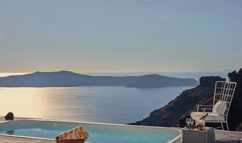 Luxurious white-walled Chromata Villa with private infinity pool overlooking Aegean Sea's blue horizon in scenic Santorini, Greece