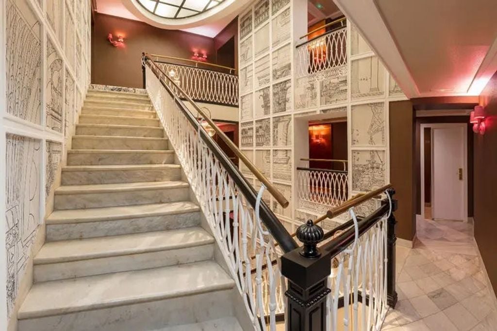 Elegant Spanish boutique hotel facade with ornate balconies, classic stone architecture, and wrought-iron details in historic setting