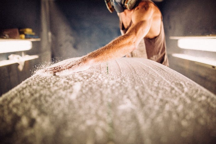 A surfboard shaper busy in shaper's alley, Maui