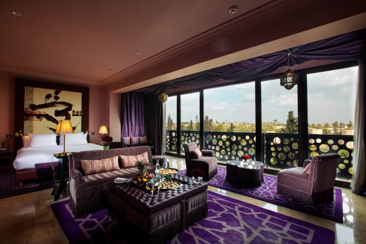 Elegant rooftop pool at Nobu Marrakech hotel with panoramic Atlas Mountains views, lined by cabanas and palm trees at golden hour