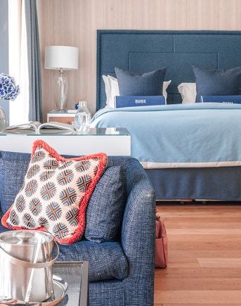 Luxurious deluxe suite overlooking Southampton marina, featuring contemporary design with private balcony and sweeping waterfront views at sunset