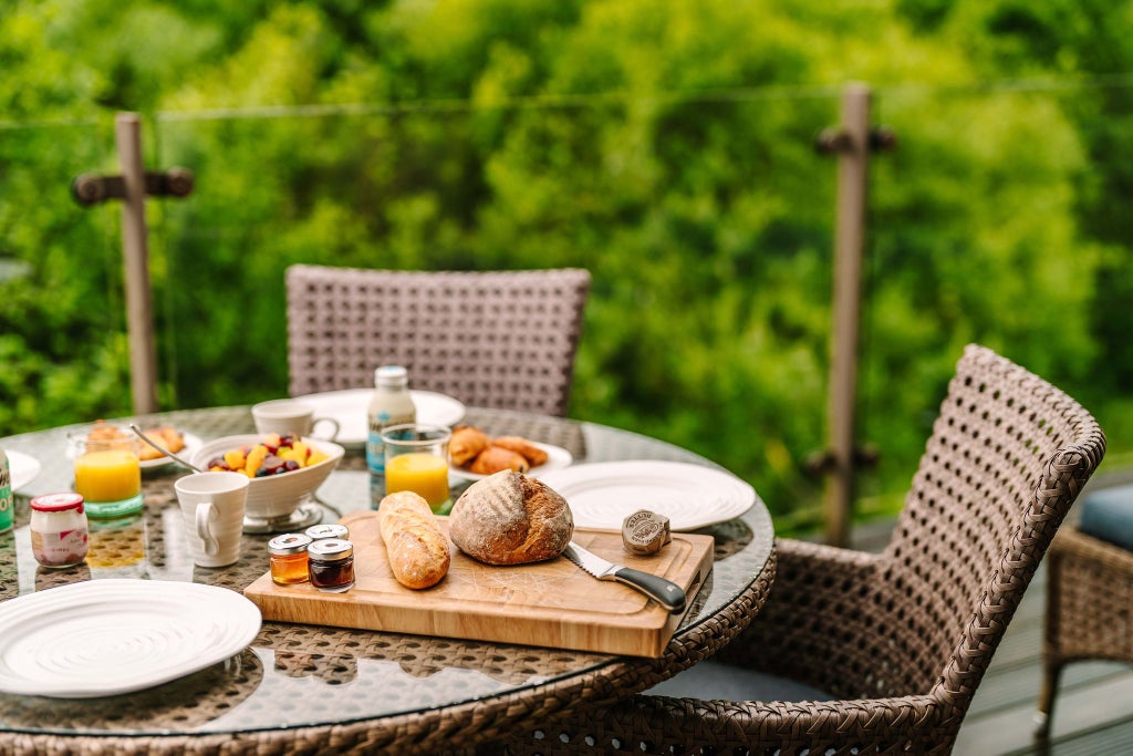 Luxurious treehouse loft suite at Chewton Glen Hotel & Spa, featuring modern wooden interiors, large windows, and elegant minimalist design in the UK.